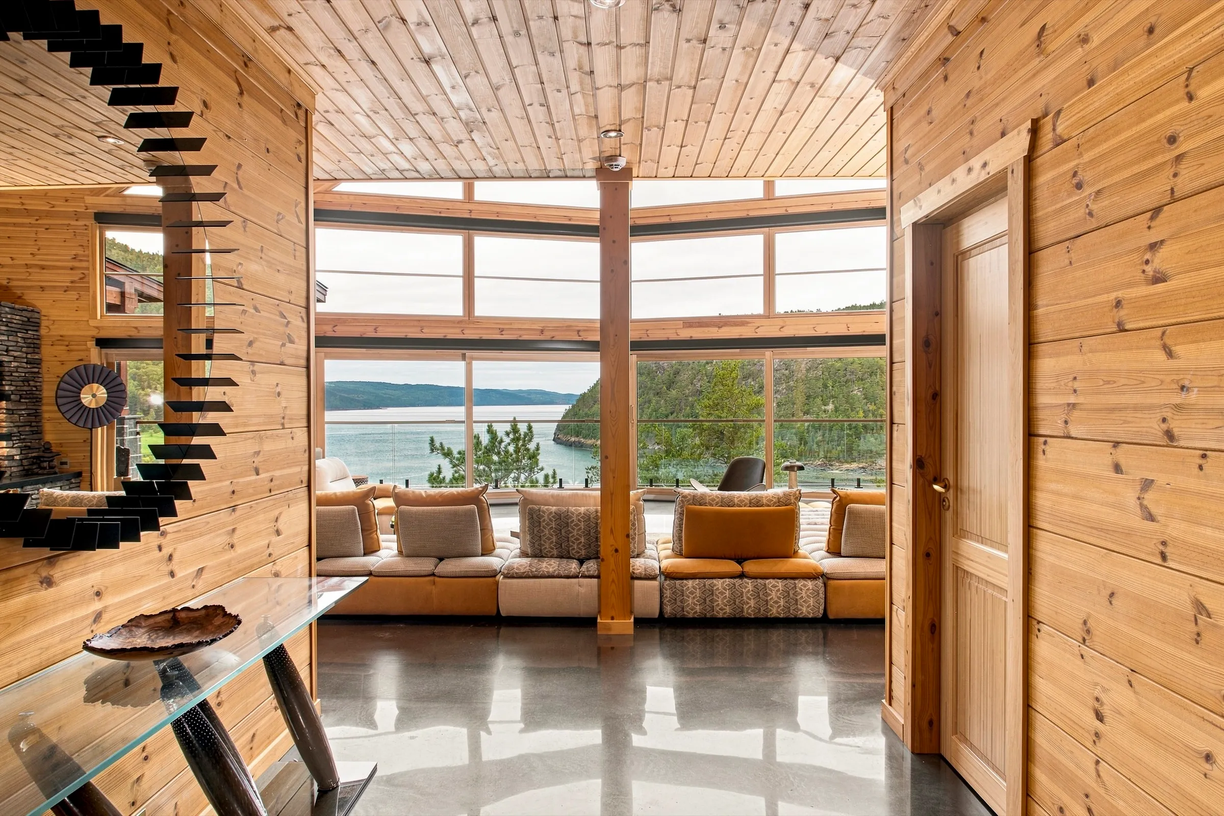 Mezzanine sous charpente de bois, escalier hélicoïdal et baie panoramique sur l’eau