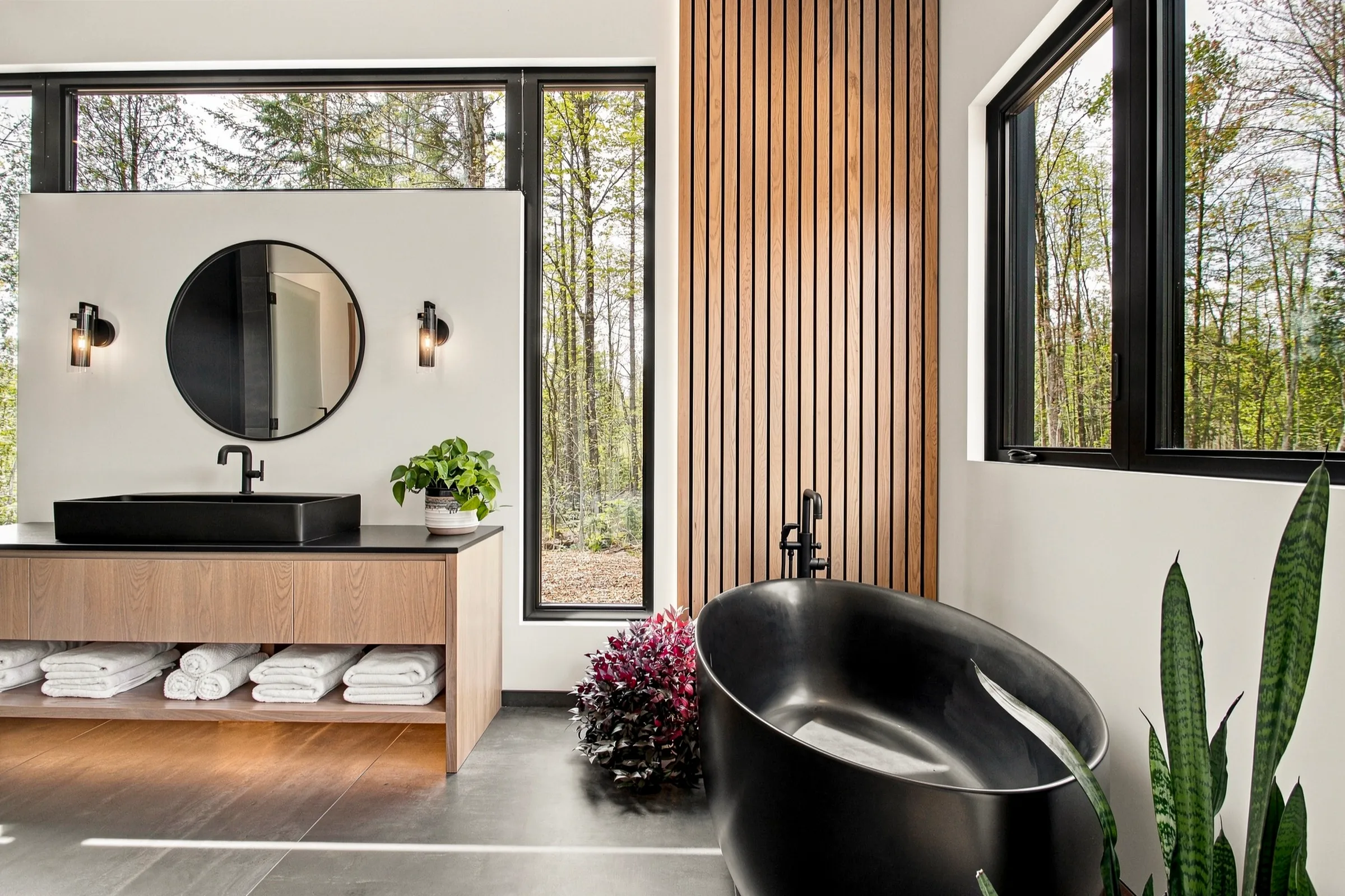 Salle de bain à lambris de bois vertical, vasque ronde et douche vitrée
