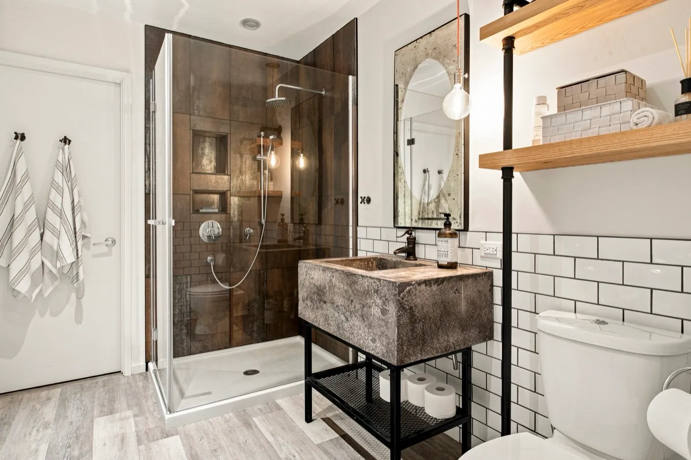 Salle de bain aux comptoirs vidés, douche dégagée et serviettes assorties suspendues